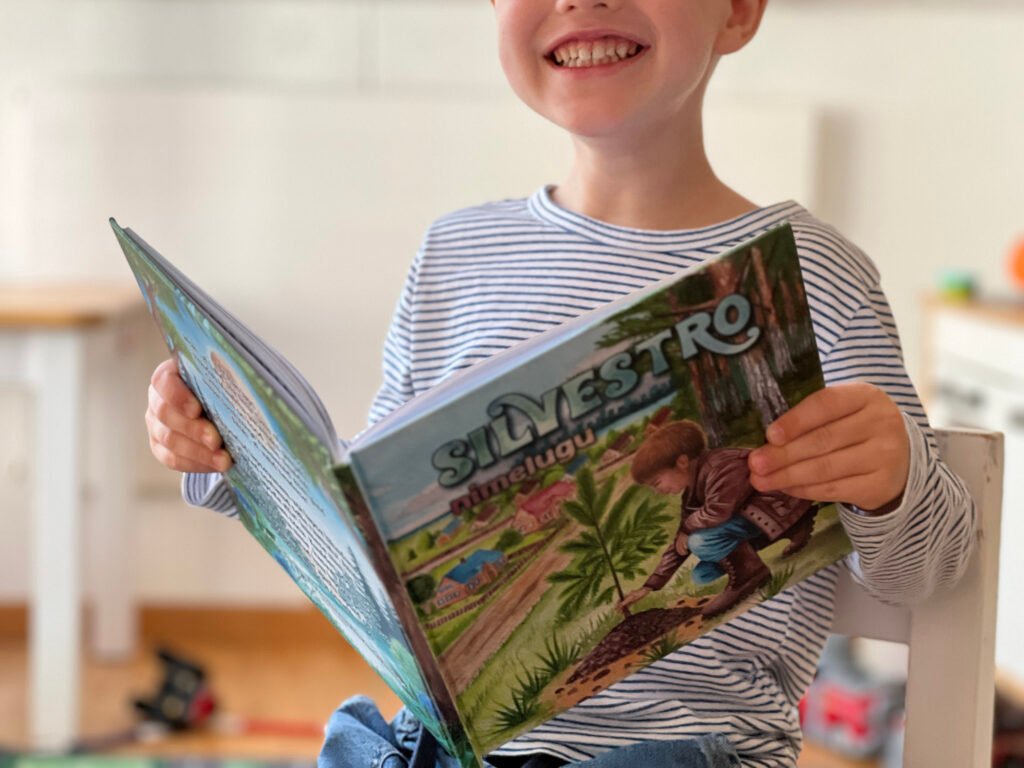 Laps loeb personaalset nimeraamatut, mis toetab lugemishuvi ja enesekindlust